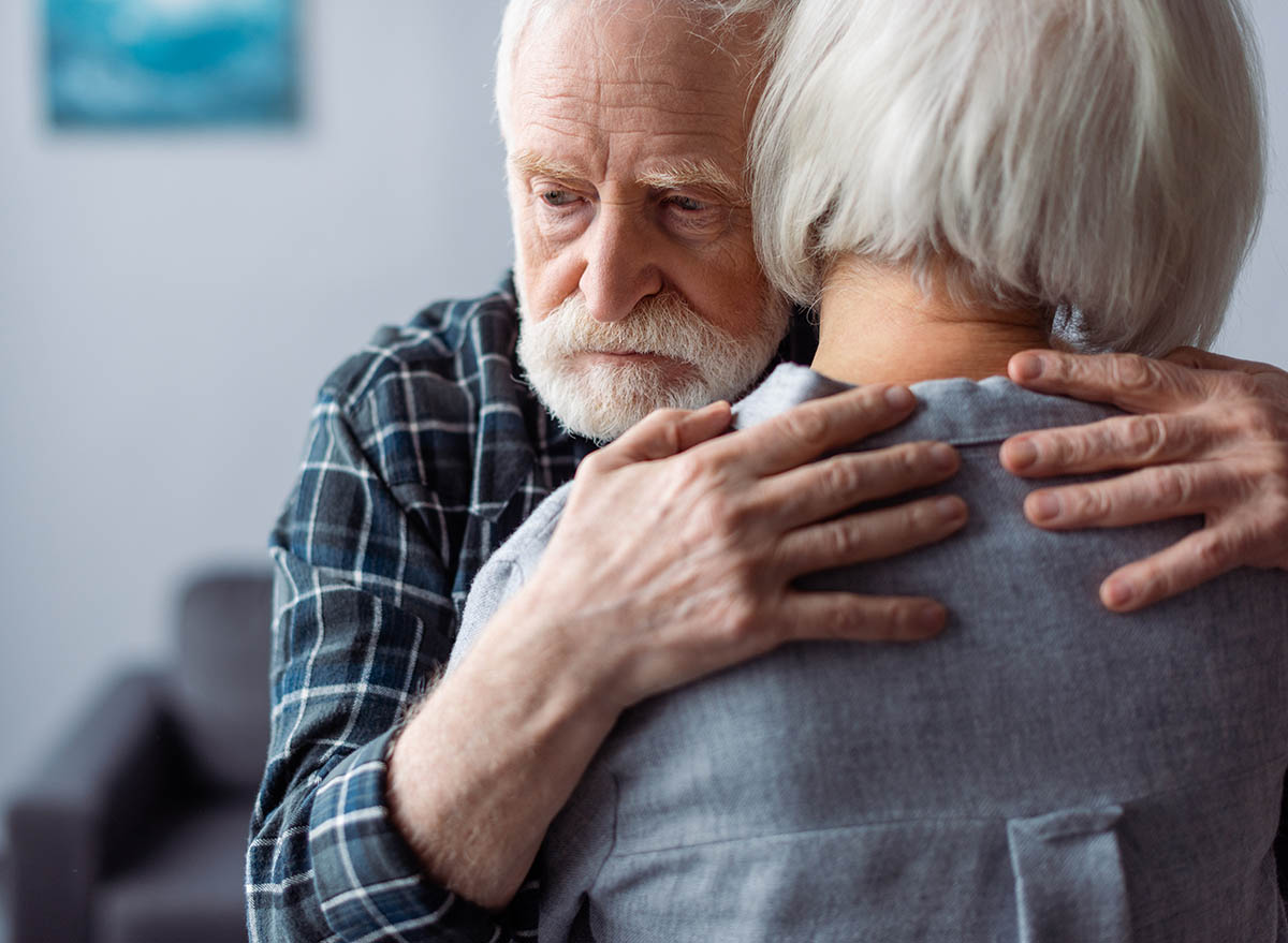 Back,View,Of,Senior,Woman,Hugged,By,Husband,,Sick,Dementia