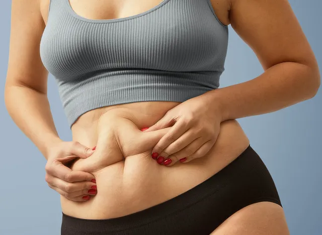 woman holding belly fat, metabolism slows down concept