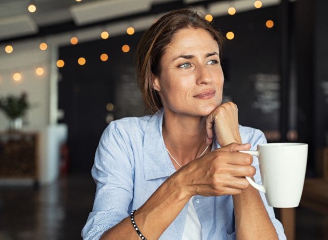 woman holding coffee mug in cafe