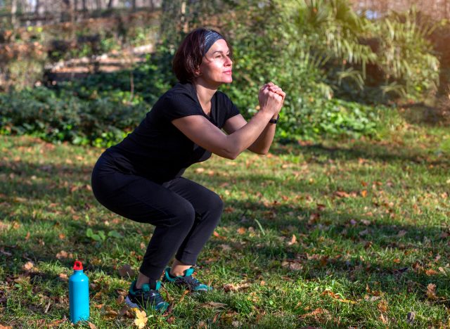 woman performing squats outdoors