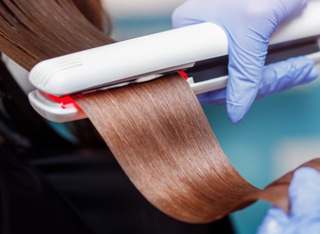close-up woman receiving hair straightening keratin treatment