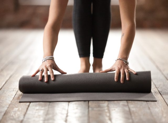 woman rolling out yoga mat