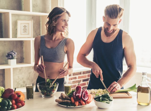 couple cooking healthy meal at home to lose weight and gain muscle