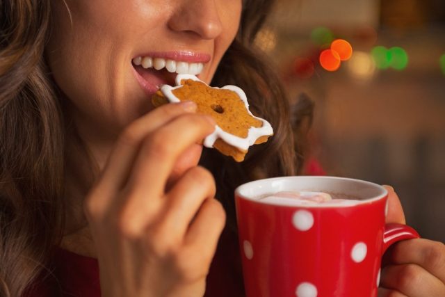 woman eating christmas cookie, get rid of holiday weight gain fast concept