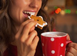 woman eating christmas cookie, get rid of holiday weight gain fast concept
