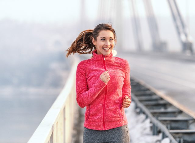 happy female runner in the winter, running tips for weight loss concept