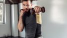 fitness man with dumbbells demonstrates how to get rid of fat rolls