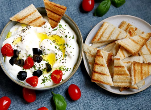 greek yogurt dip with olives, tomatoes, and bread