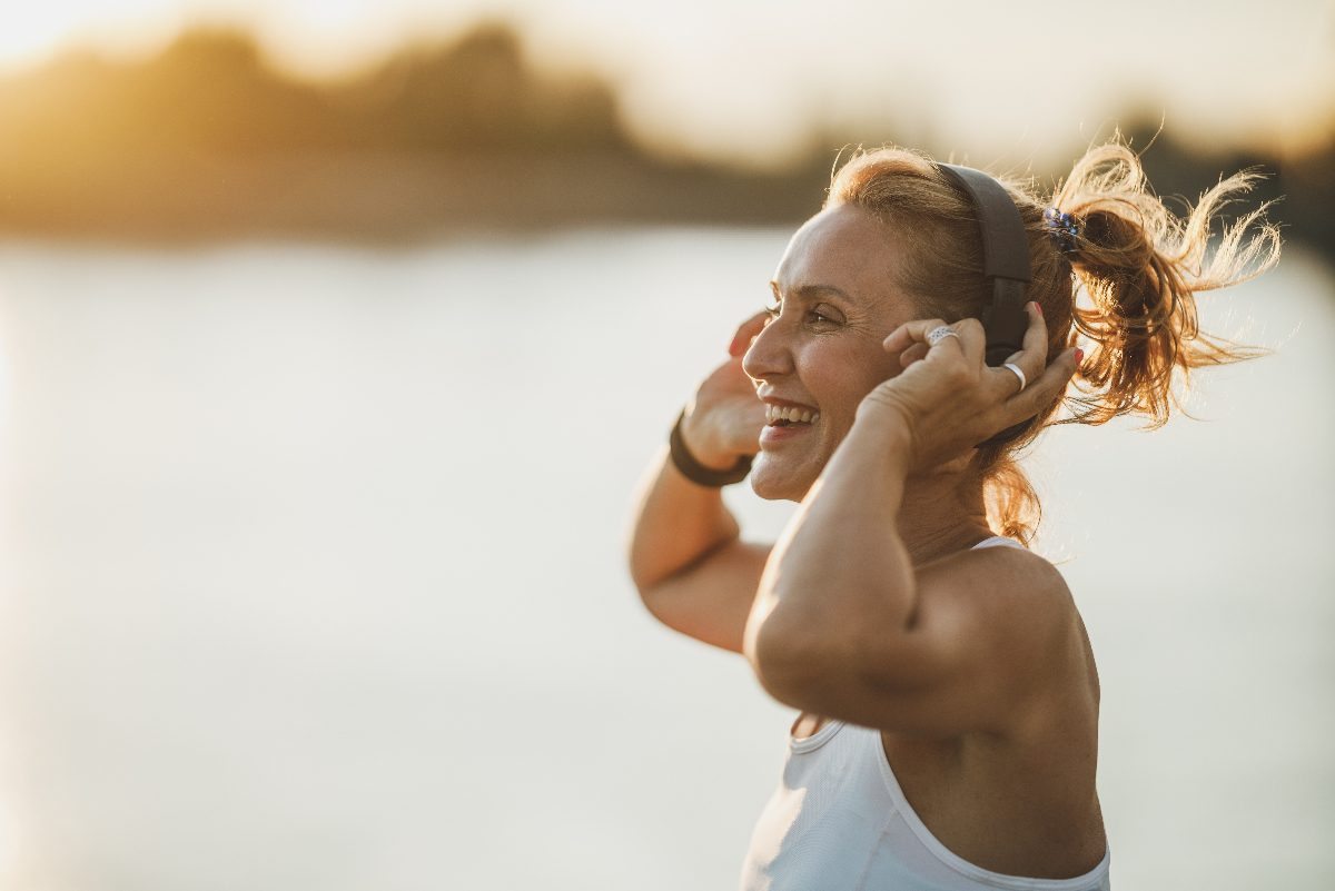 happy woman jogging by the beach on a sunny day