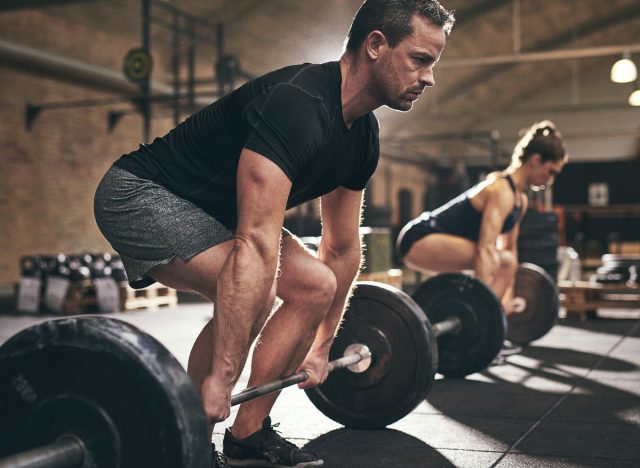 man performing barbell deadlift, concept of exercises for men to bulk up