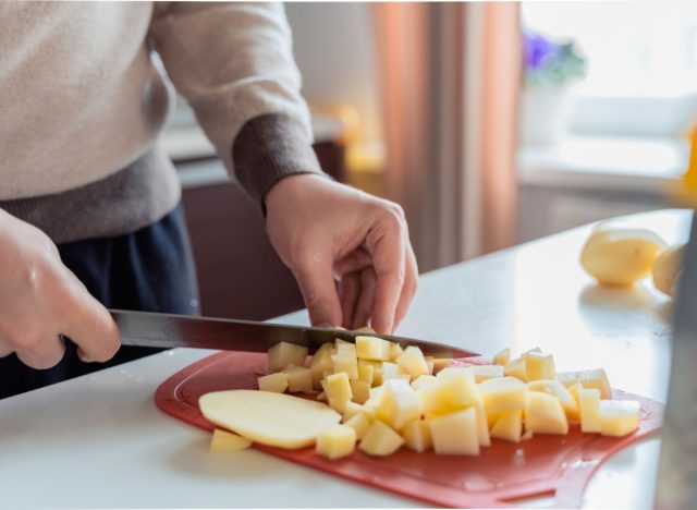 man cutting potatoes