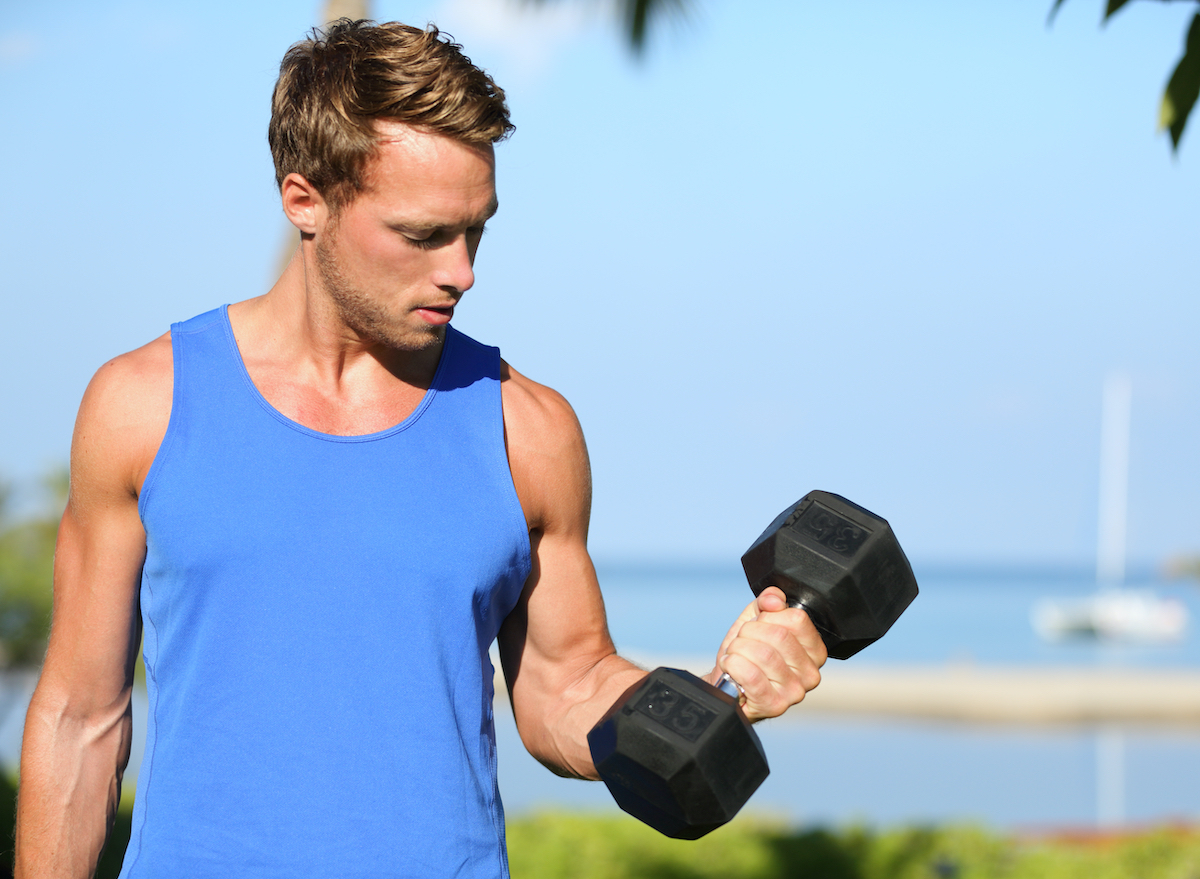 man performing dumbbell bicep curls part of standing ab workout