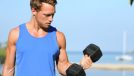 man performing dumbbell bicep curls part of standing ab workout