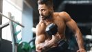 fit man at gym performing dumbbell exercises for sleeve-busting biceps