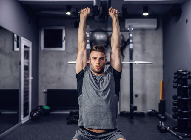man lifting heavy dumbbells, concept weight lifting myths