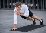 Człowiek wykonujący ćwiczenia deski, aby stracić pięć cali tłuszczu z brzucha