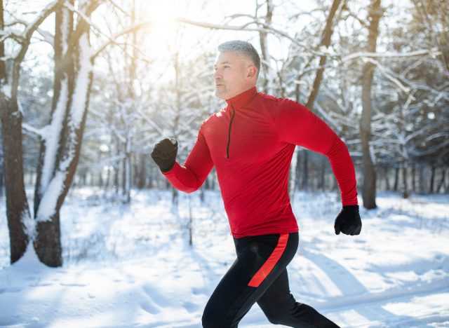 Man running outside in the snow, healthy vacation habits for weight loss