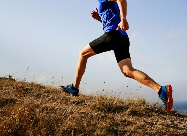 man running uphill outdoors to double the belly fat burn