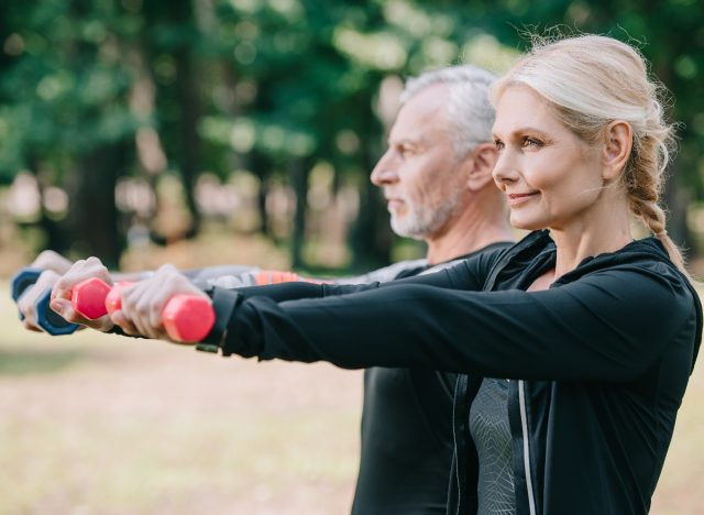 mature fitness couple using dumbbells for exercises to slow aging in your 50s