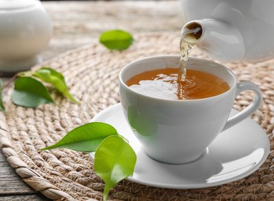 pouring green tea into tea cup