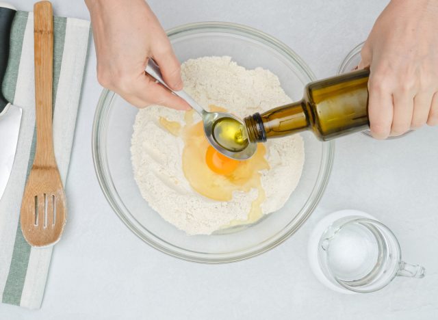 pouring oil into bowl of flour and eggs