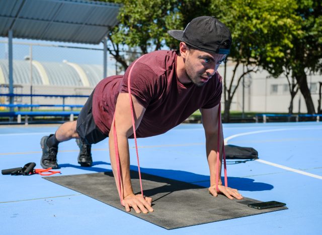 man performing resistance band pushups