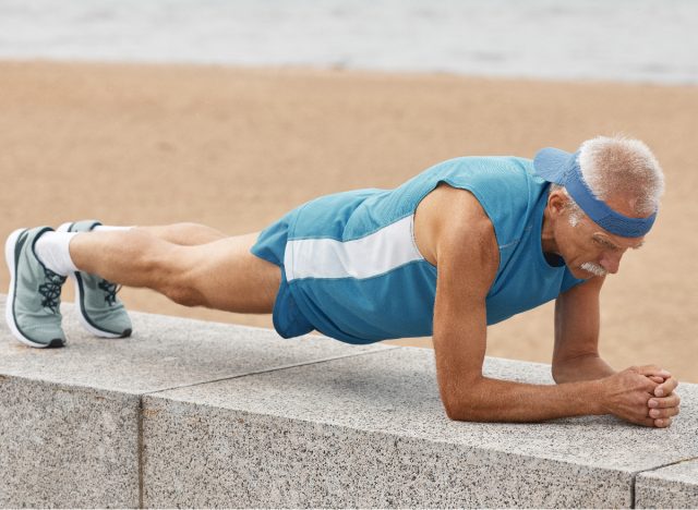 strong senior man performing plank exercises to improve muscular endurance