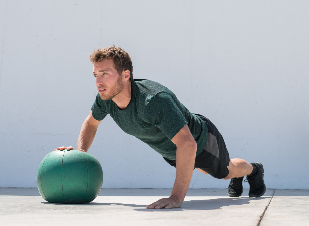 man performing stability ball strength training exercises to shrink pot belly fat