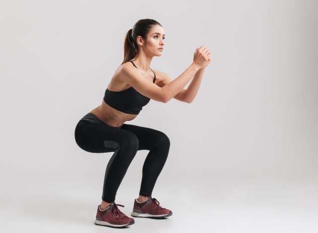 Woman performing twisted squat jumps