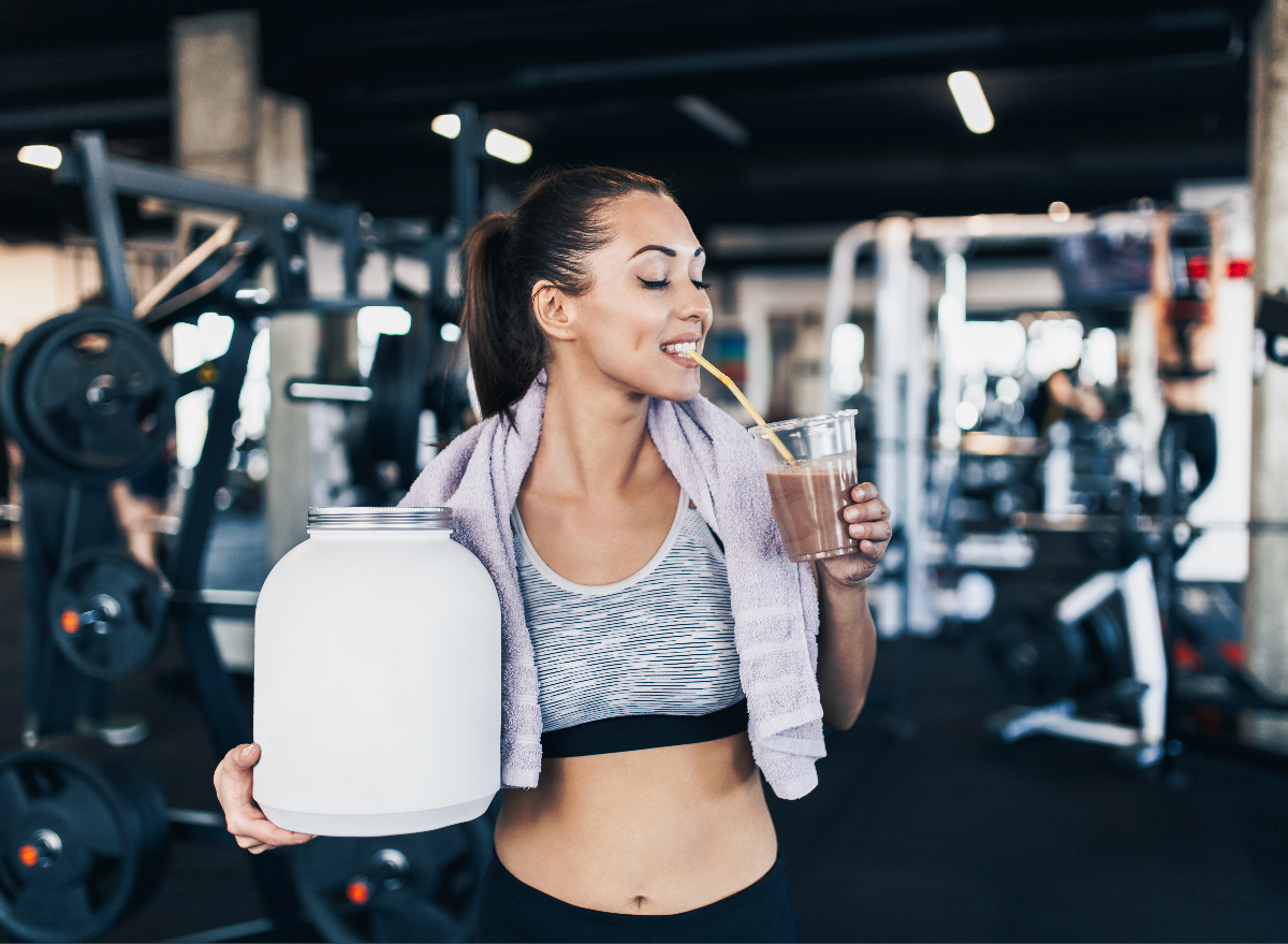 https://www.eatthis.com/wp-content/uploads/sites/4/2022/11/woman-drinking-protein-shake-gym.jpg?quality=82&strip=1