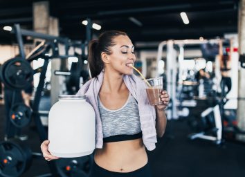 woman drinking protein shake when working out