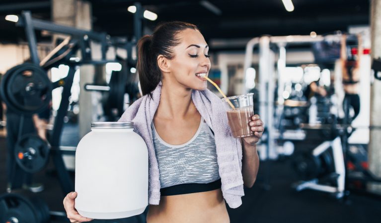 woman drinking protein shake when working out
