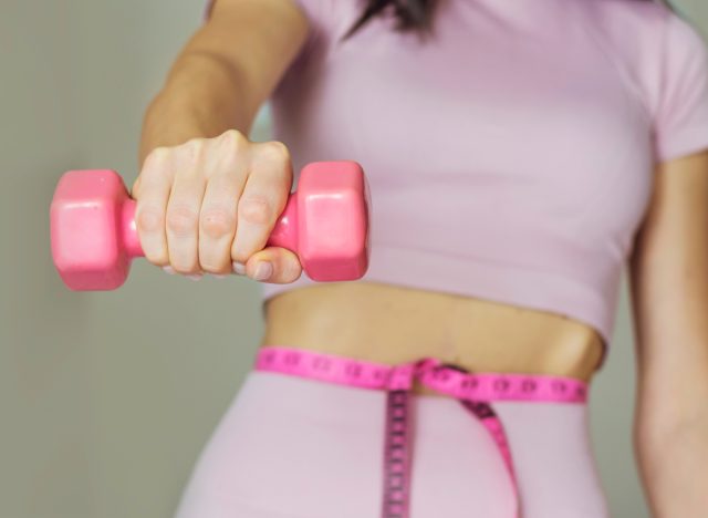 woman holding pink dumbbell weight loss concept