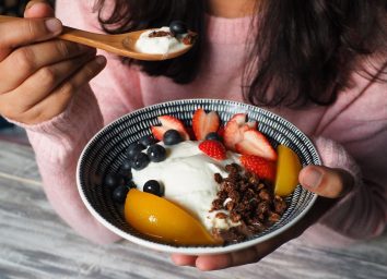 woman eating bowl of fruit and yogurt for weight loss