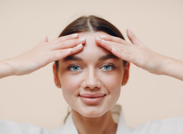 woman performing face tapping exercise to get rid of chubby cheeks