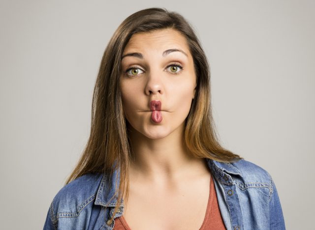 woman demonstrates fish face exercise to get rid of chubby cheeks