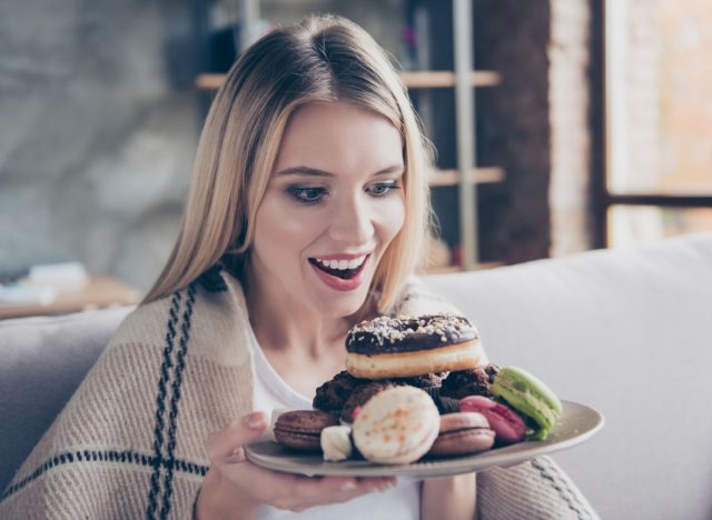 woman holding plate of desserts