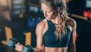 woman demonstrates how to gain muscle mass with dumbbell exercises at gym
