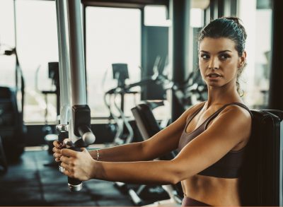 woman performing machine workout exercises for a slimmer figure