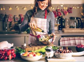 woman prepares holiday meal in kitchen, healthy holiday habits for weight loss