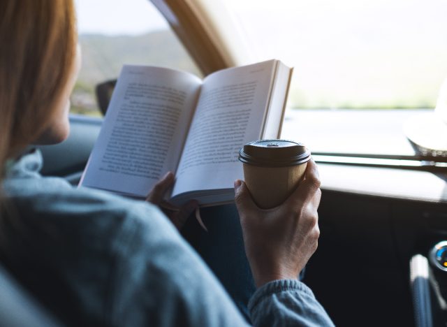woman reading a book on a road trip
