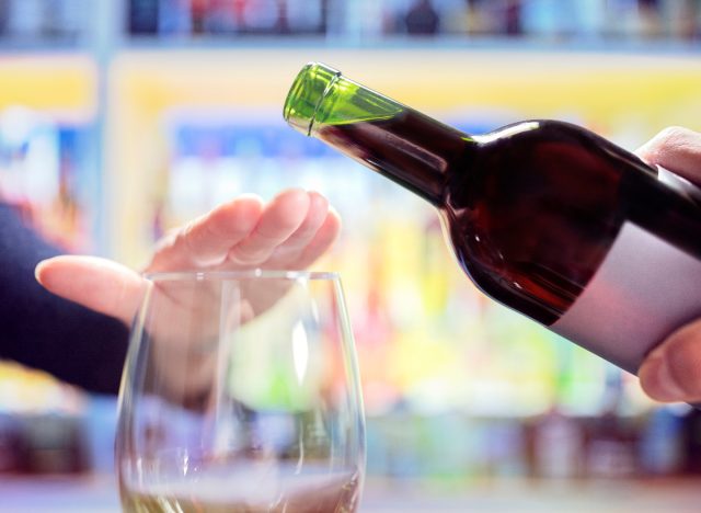 kvinna vägrar mer alkohol, vinflaska