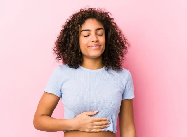 woman smiling and holding stomach