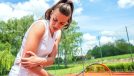 woman dealing with tennis elbow pain on the court