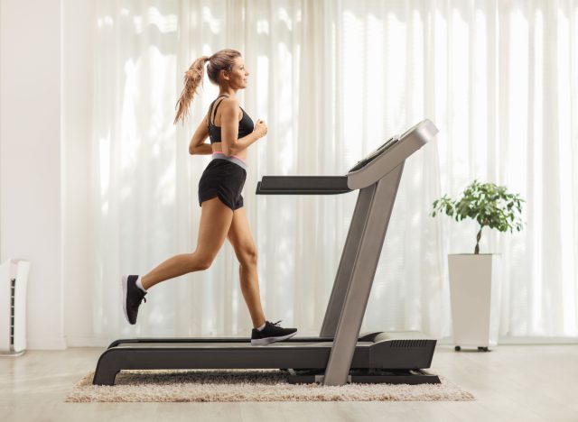 A woman does cardio on a treadmill to double her belly fat burn