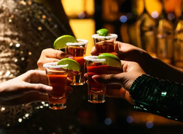 woman holding tequila shots