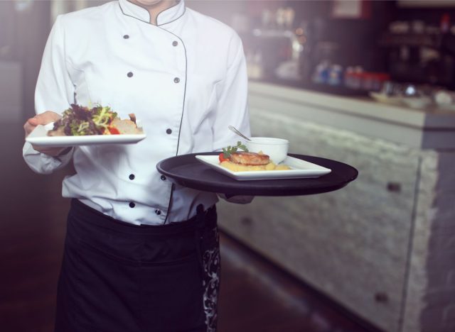 A waiter holding plates of food