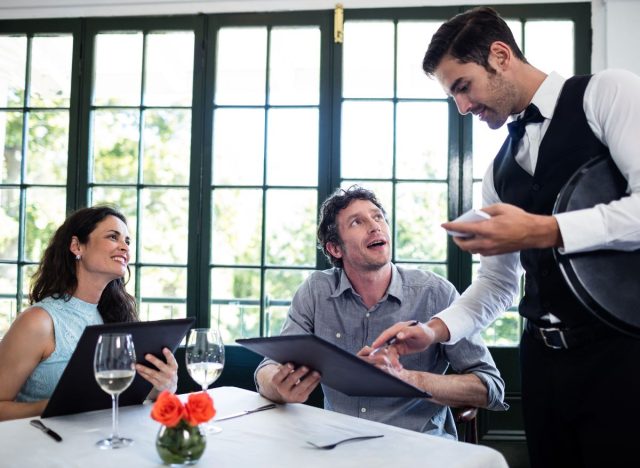 A waiter taking customers' orders