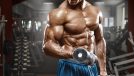 muscular man holding dumbbells, concept of 10-minute arm workout at gym