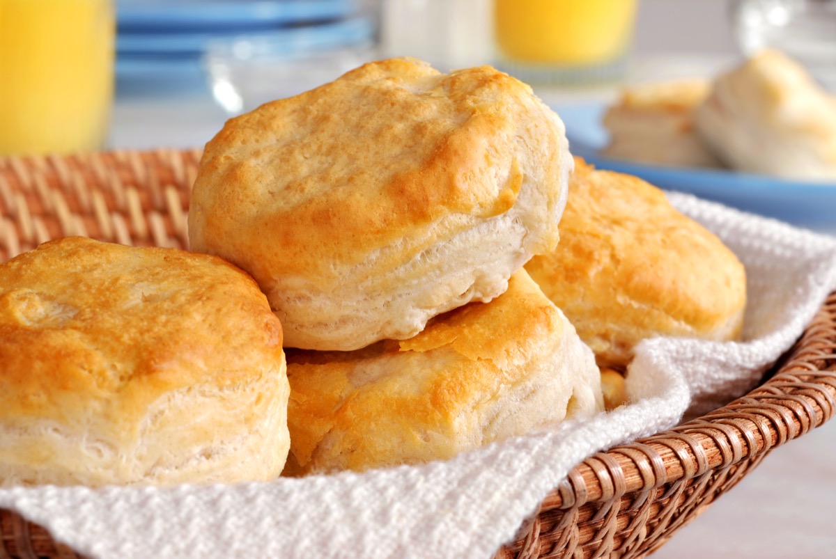 Basket,Of,Freshly,Baked,Biscuits,With,Orange,Juice,And,Tableware